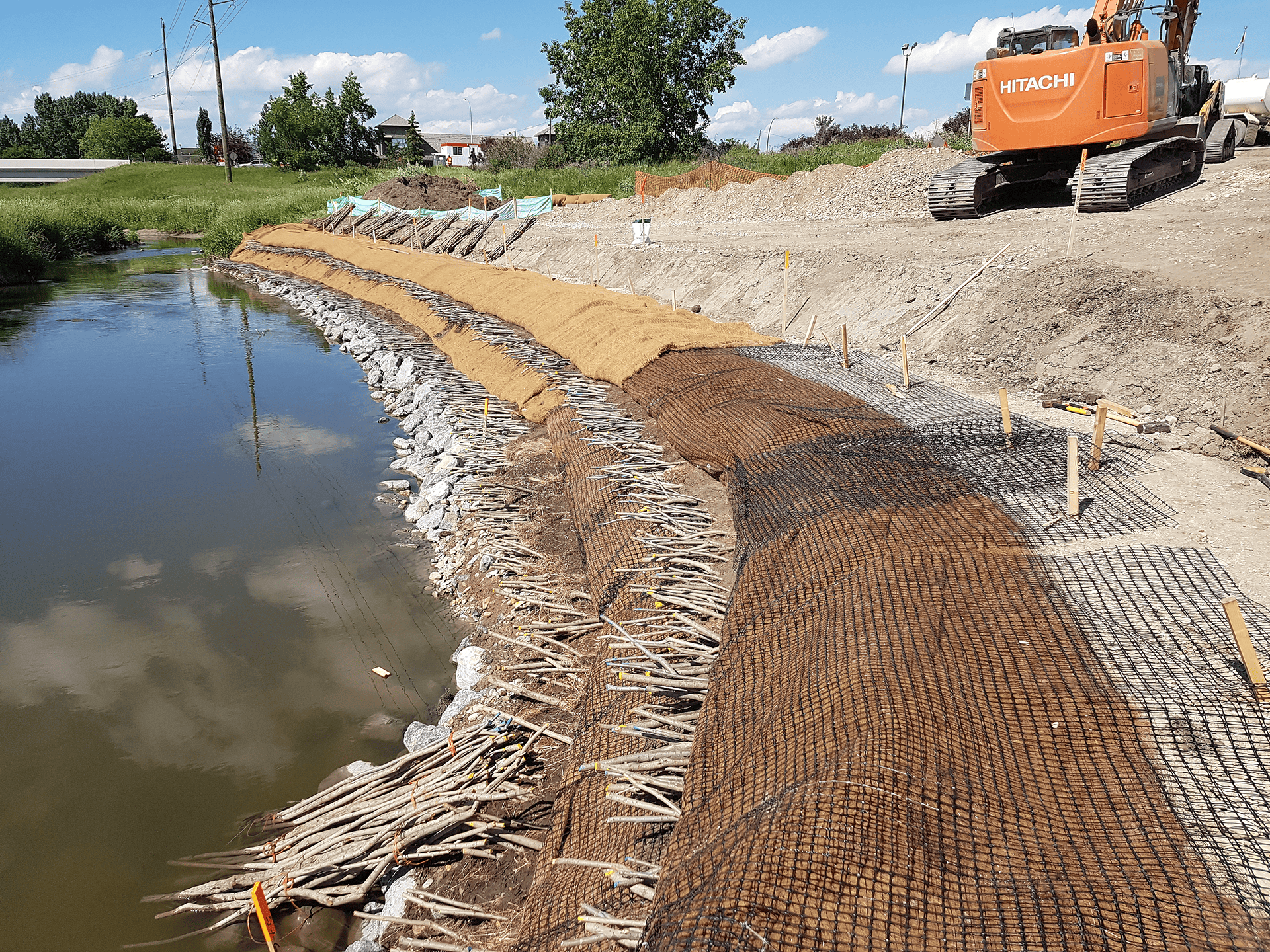 a backhoe sits on a remediated bank for palmer bridge site